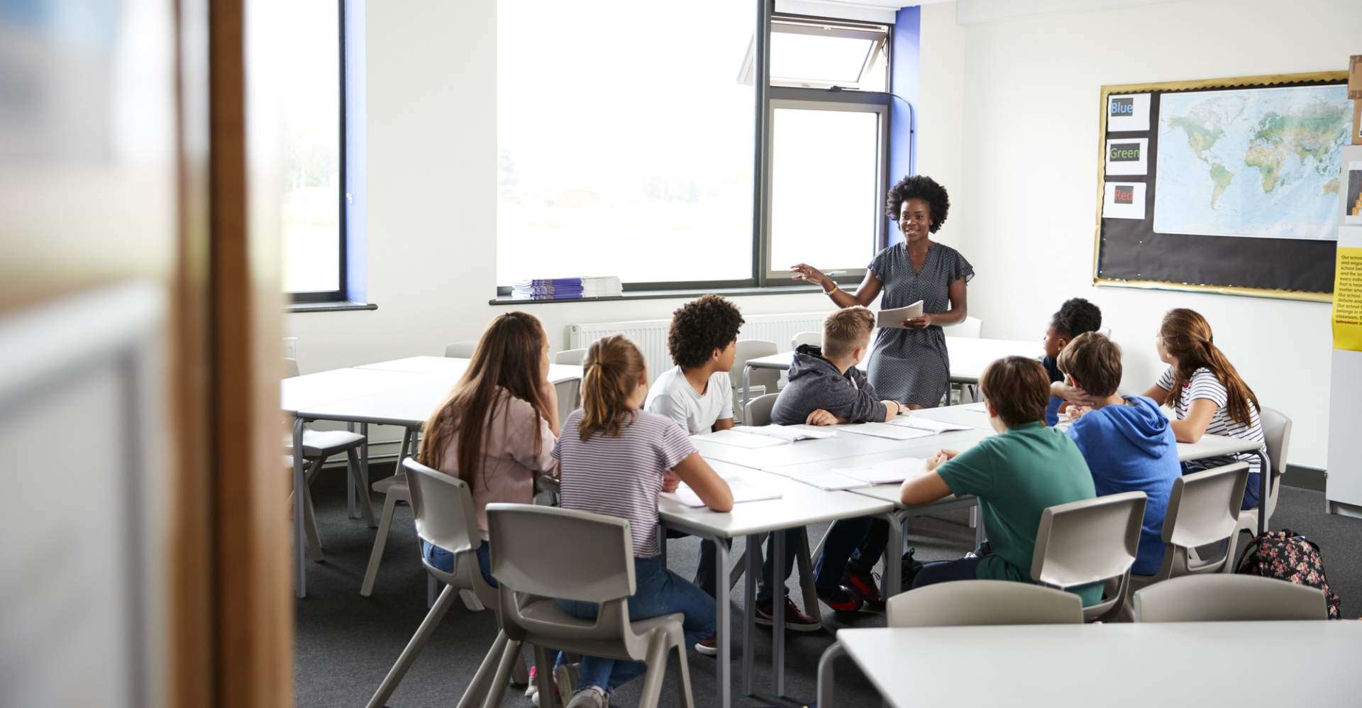 African American female teacher standing before a table of students